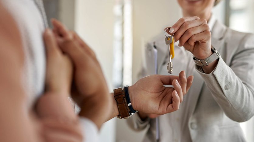 closeup couple receiving keys their new apartment from real estate agent
